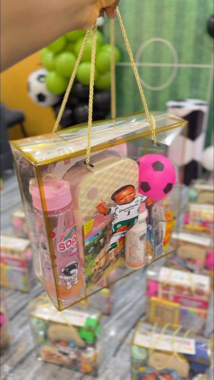 Clear plastic gift bag filled with soccer-themed toys and a pink water bottle.