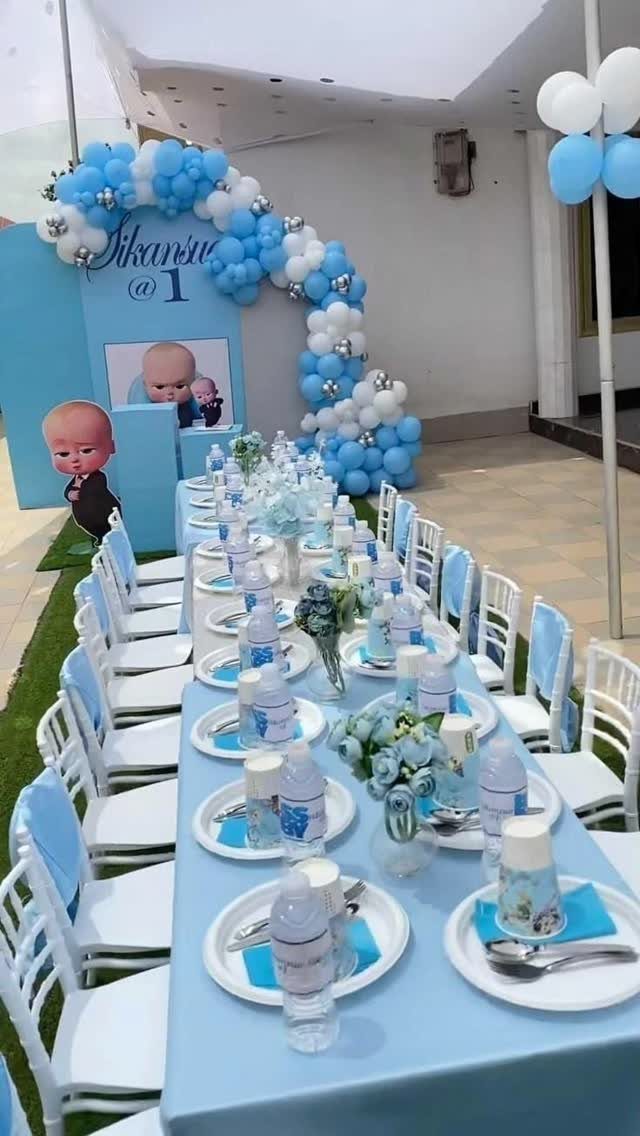 Blue and white themed birthday table setting with a matching balloon arch backdrop.