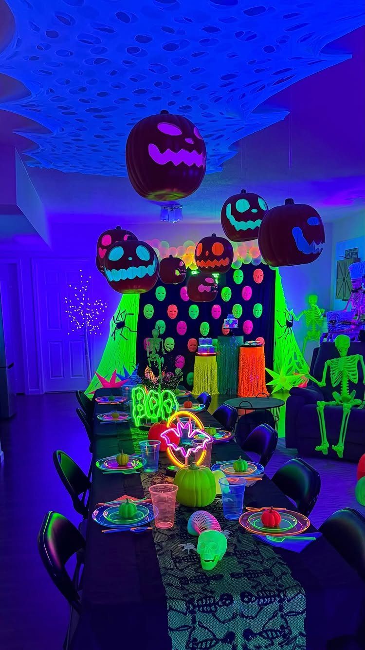 Neon Halloween party setup with glowing pumpkin balloons and a decorated dining table.