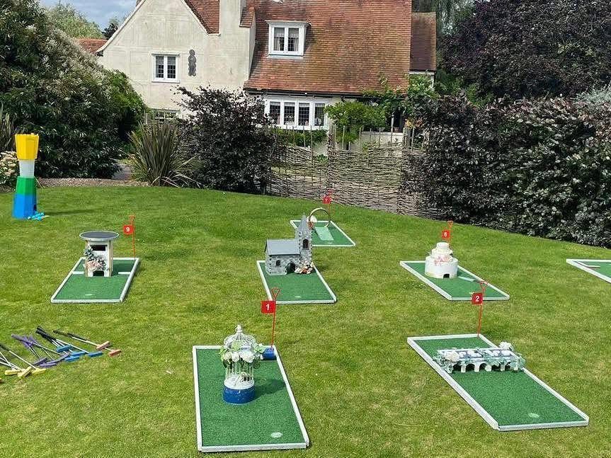 Miniature golf course set up on a green lawn in a residential backyard