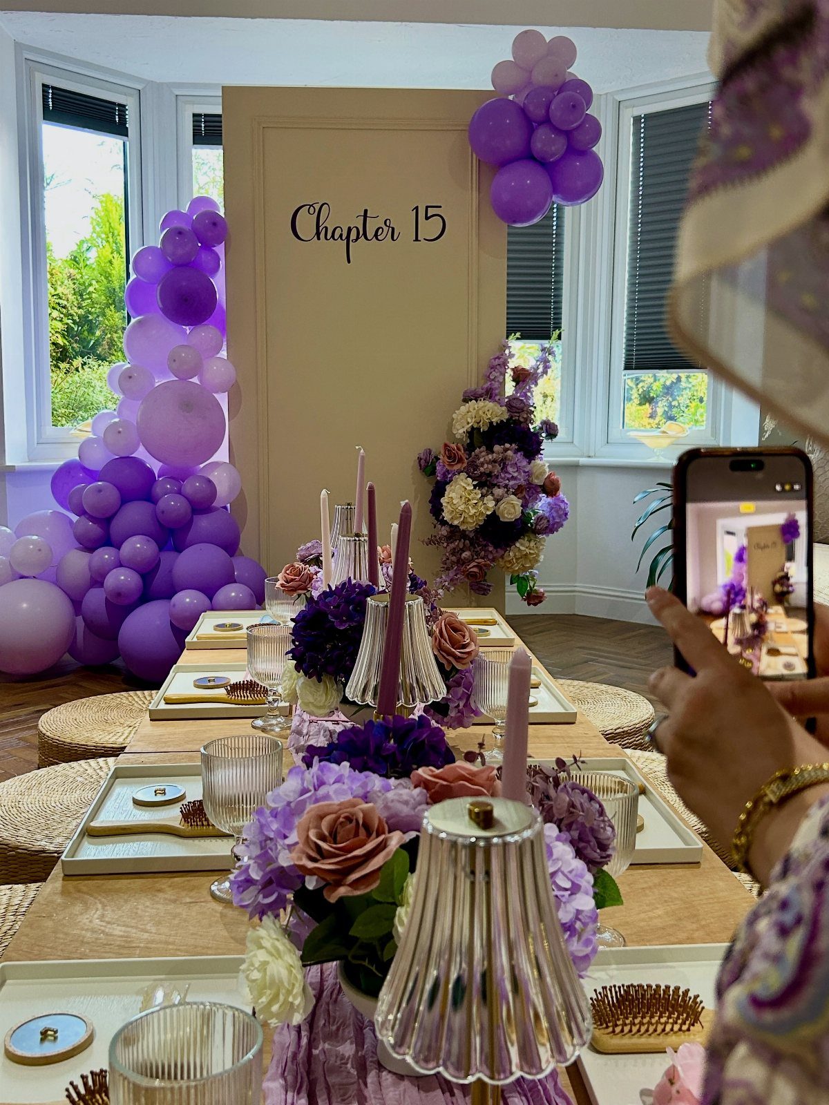 Purple balloon arches and a table set for a 15th birthday party celebration.