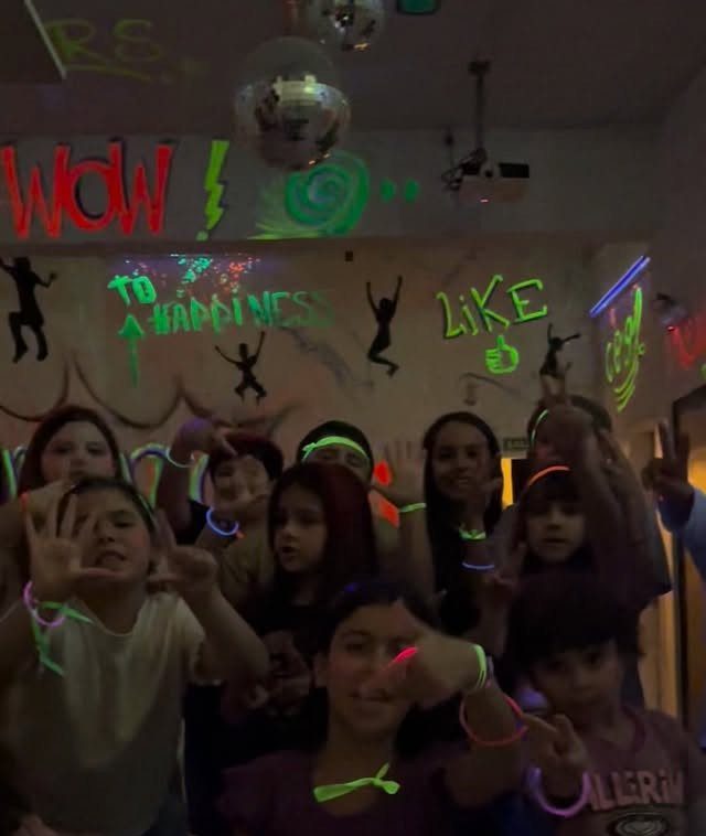 Group of girls wearing neon glow sticks at a glow-in-the-dark birthday party.