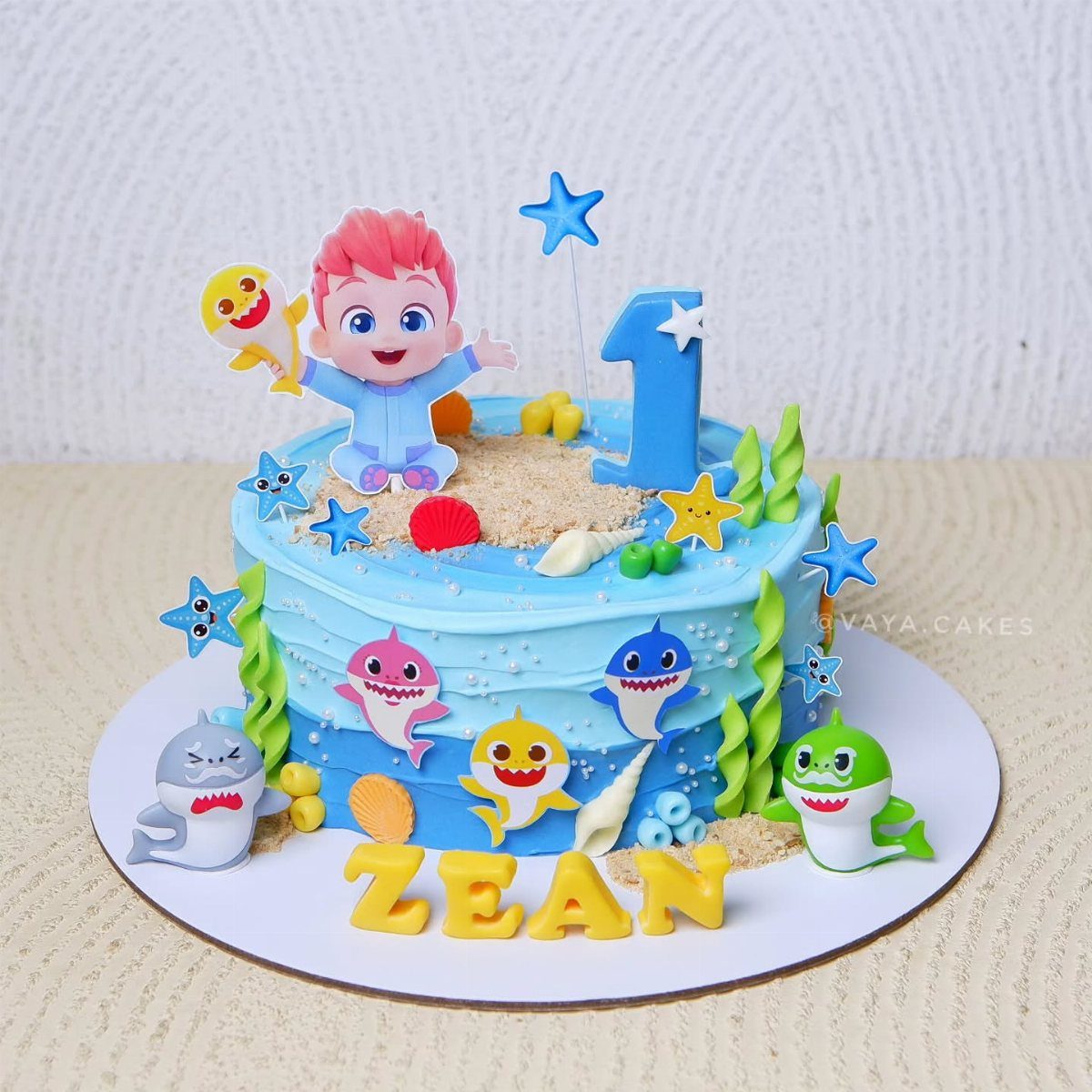 Baby Shark themed birthday cake with blue frosting, fondant sharks, and a number one.