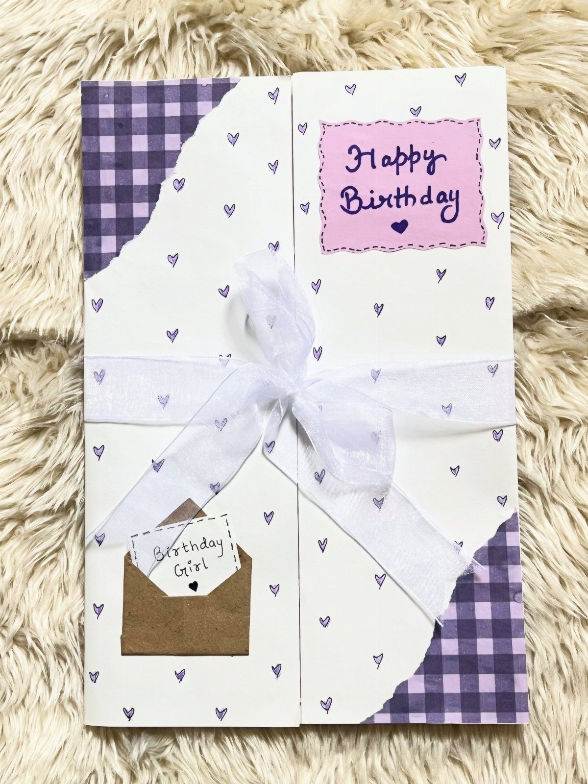 Handmade birthday card with purple accents, white ribbon, and a small brown envelope.