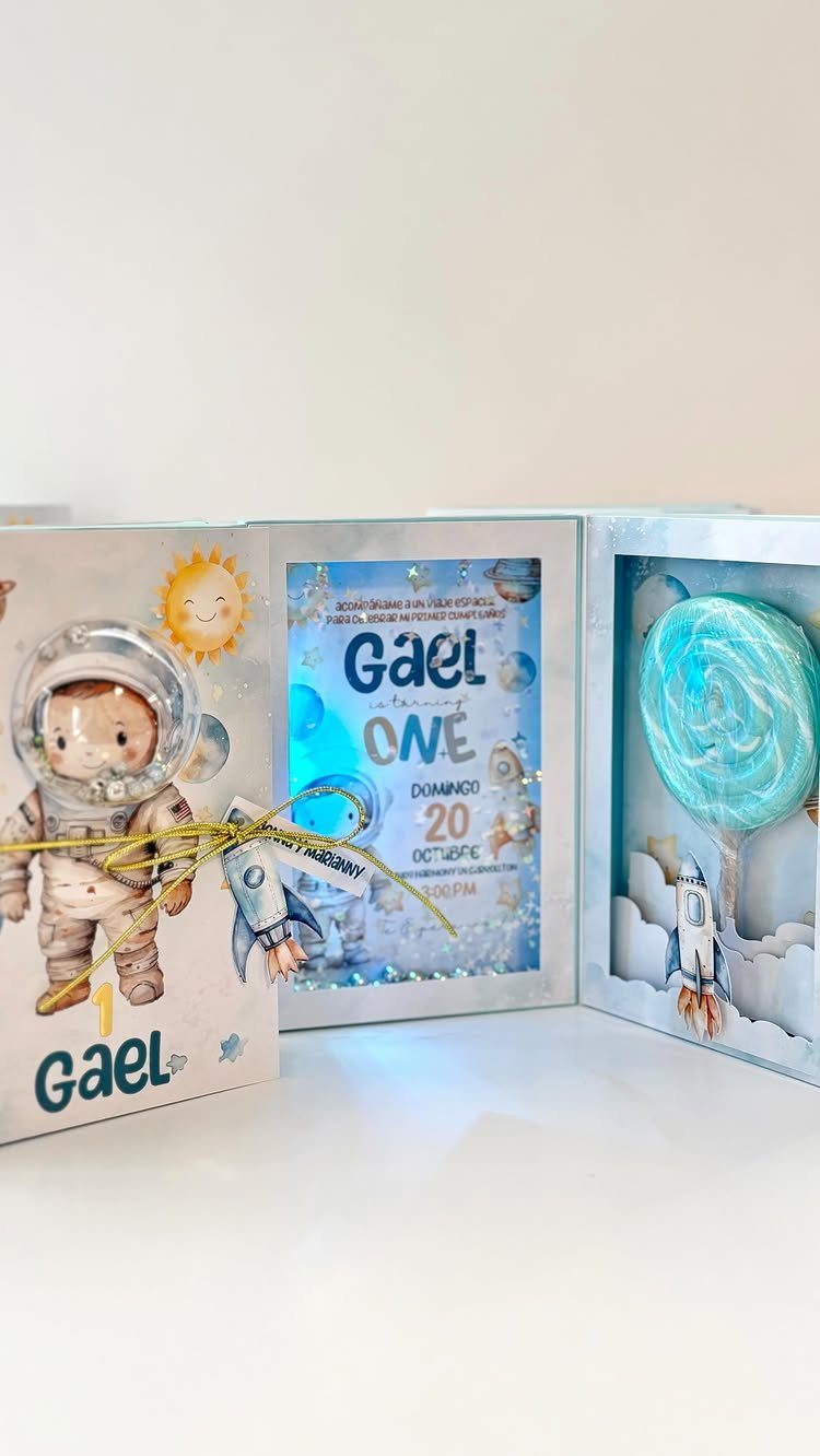 Space themed first birthday invitations featuring a cute astronaut and a rocket ship.