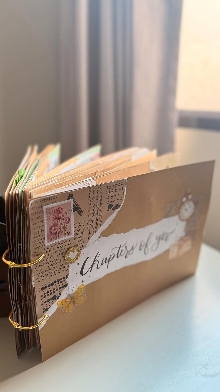 Handmade brown scrapbook with gold rings and a label reading Chapters of you.