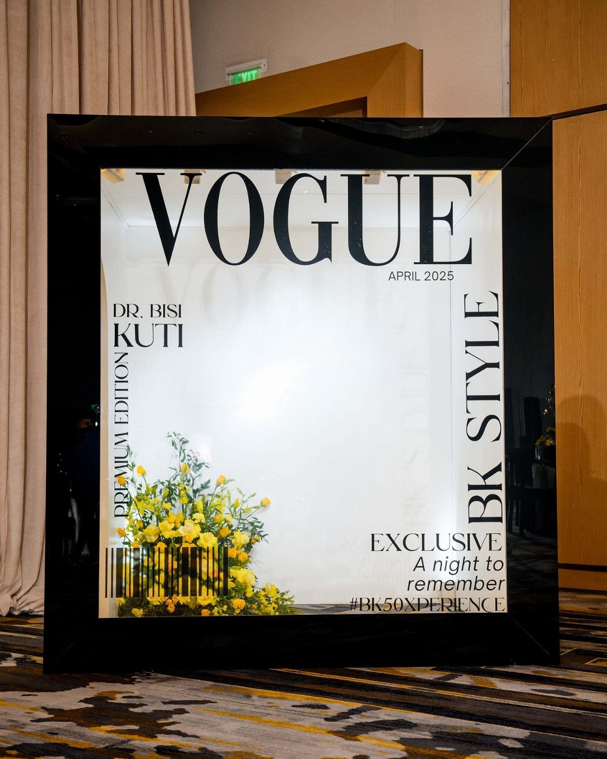 Vogue magazine cover photo booth frame with yellow flowers on a patterned carpet