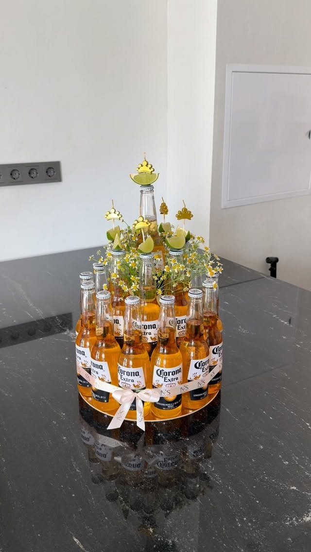 Beer cake made of Corona bottles decorated with limes and yellow flowers.