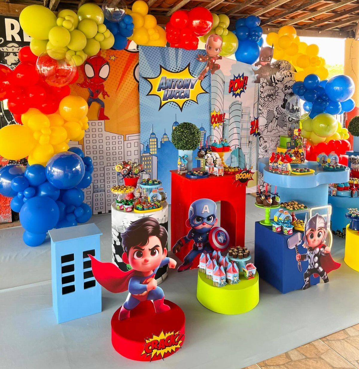 Superhero party decorations with colorful balloons, comic backdrops, and character cutouts.