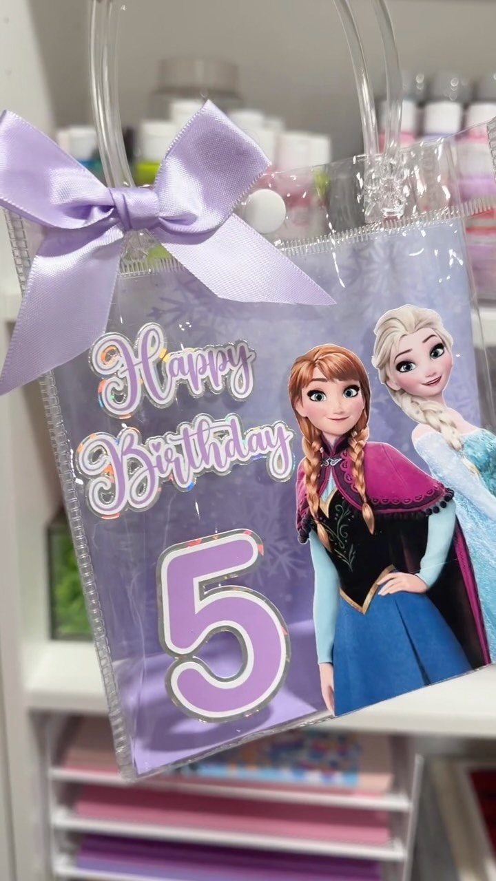 Clear plastic party bag with Frozen characters, purple bow, and number 5.