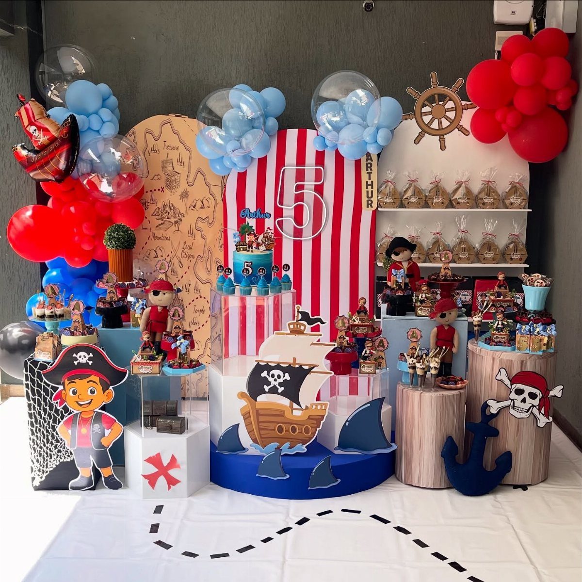 Pirate themed birthday party decorations with balloons, a ship cutout, and treasure map.
