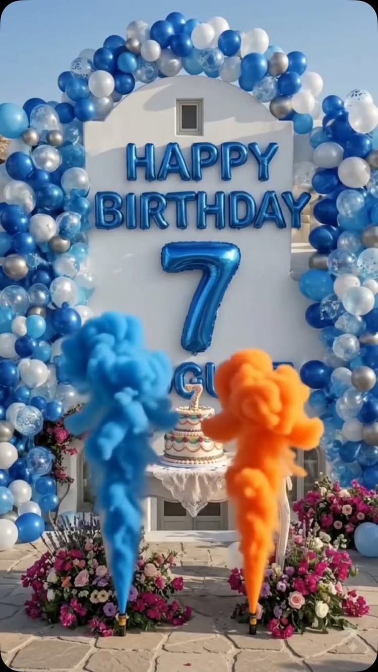 Birthday party setup with blue balloon arch, number 7, and colorful smoke plumes.