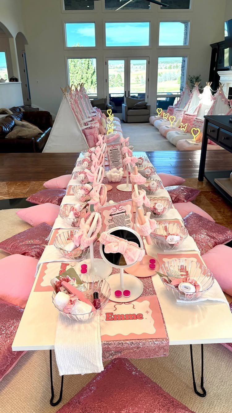 Pink themed slumber party setup with teepee tents and a decorated treat table.