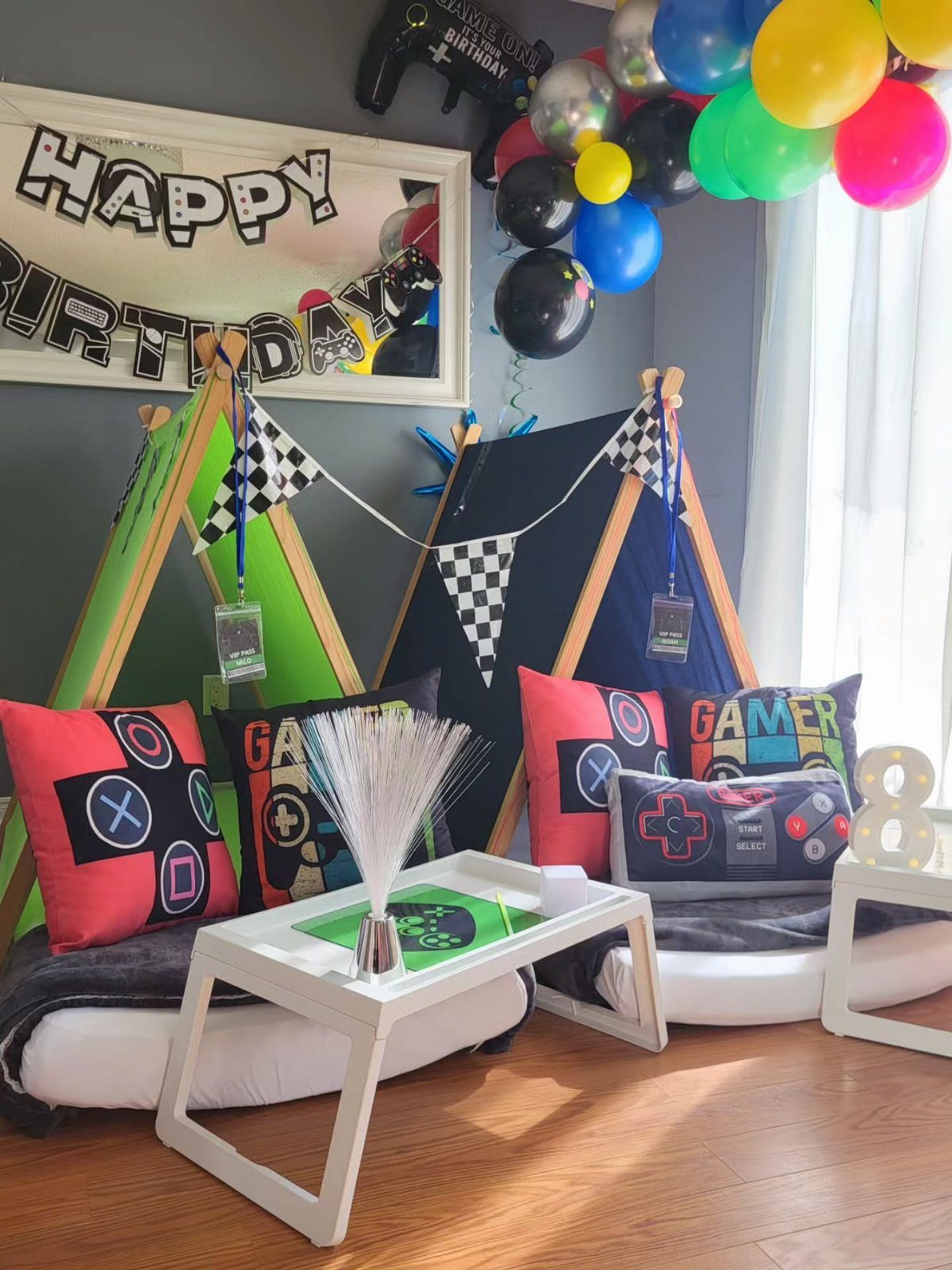 Gaming themed birthday party setup with tents, controller pillows, and colorful balloons.