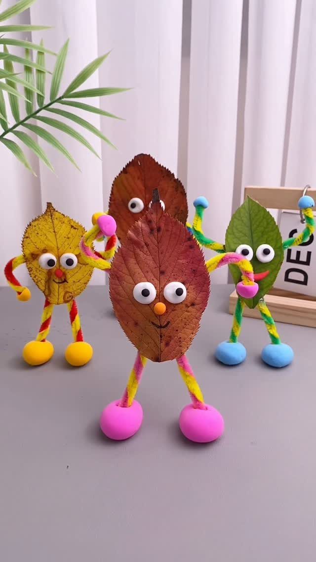 Autumn leaf craft figures with googly eyes and colorful pipe cleaner limbs.