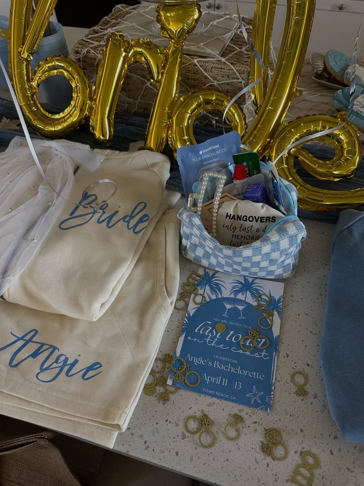 Bachelorette party sleepover kit with personalized pajamas, gift basket, and gold bride balloons.