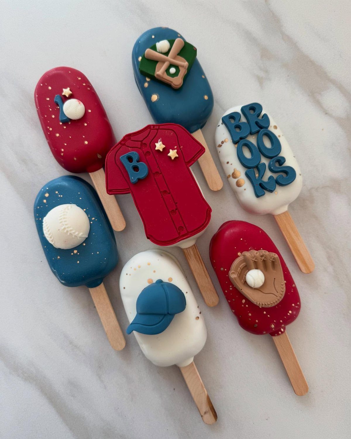 Baseball-themed cake pops decorated with a jersey, baseball, glove, and name Brooks.