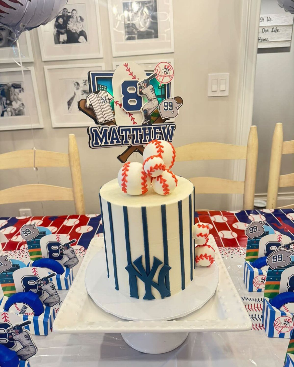 Baseball-themed birthday cake with blue stripes, Yankees logo, and baseball toppers.