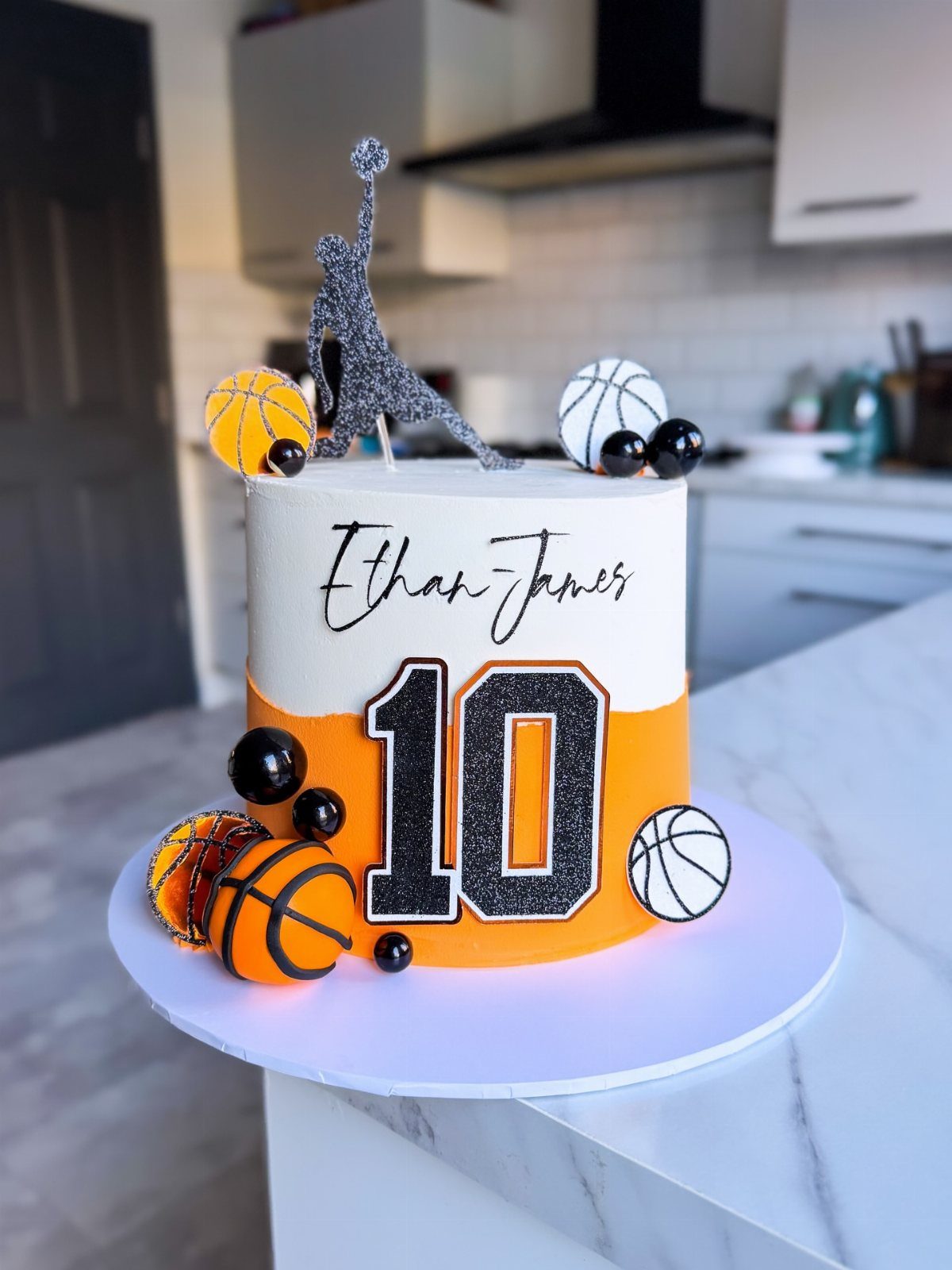 Basketball birthday cake with orange and white frosting, number 10, and player topper.