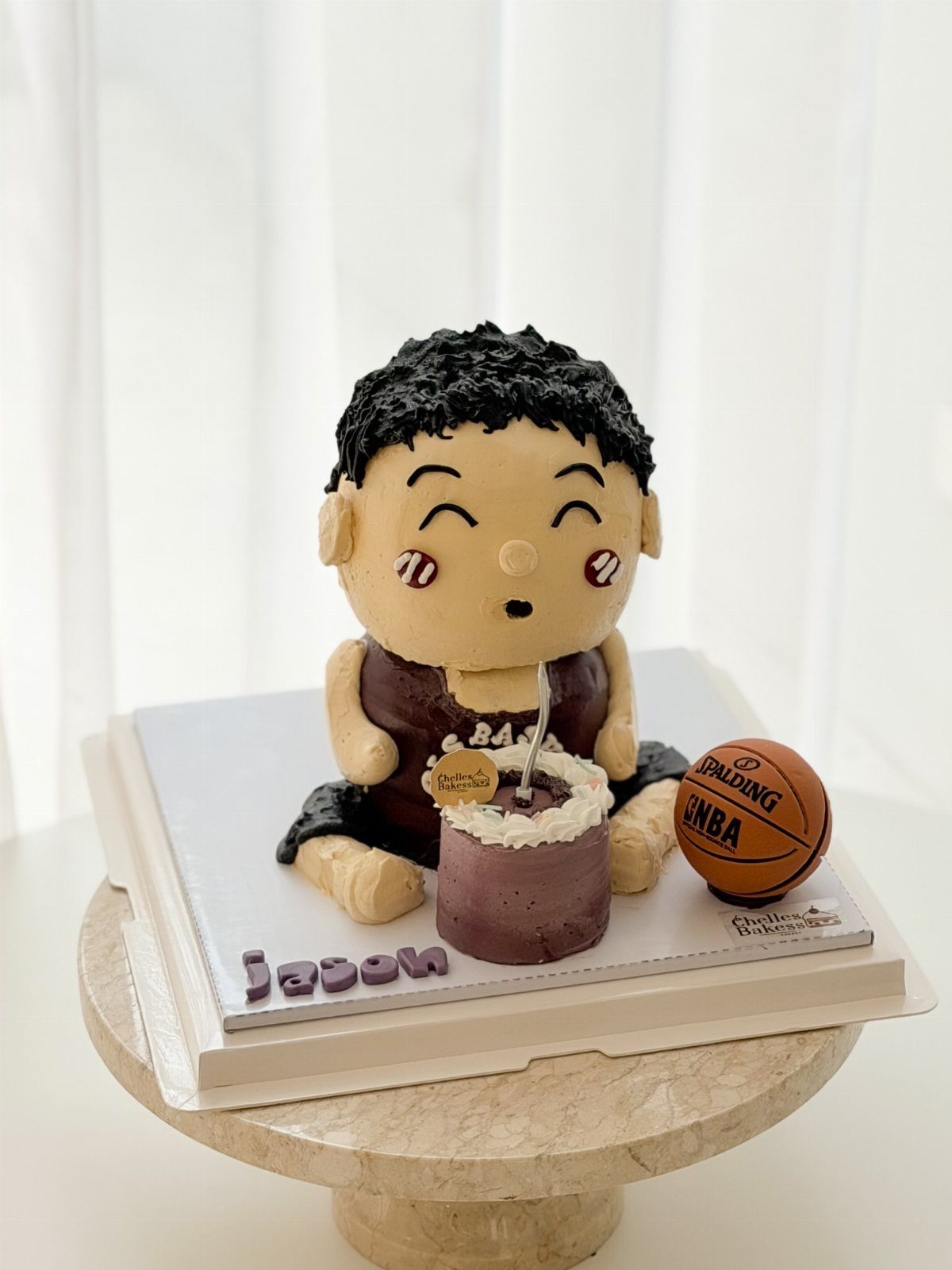 Basketball themed birthday cake featuring a boy figure and a miniature basketball.