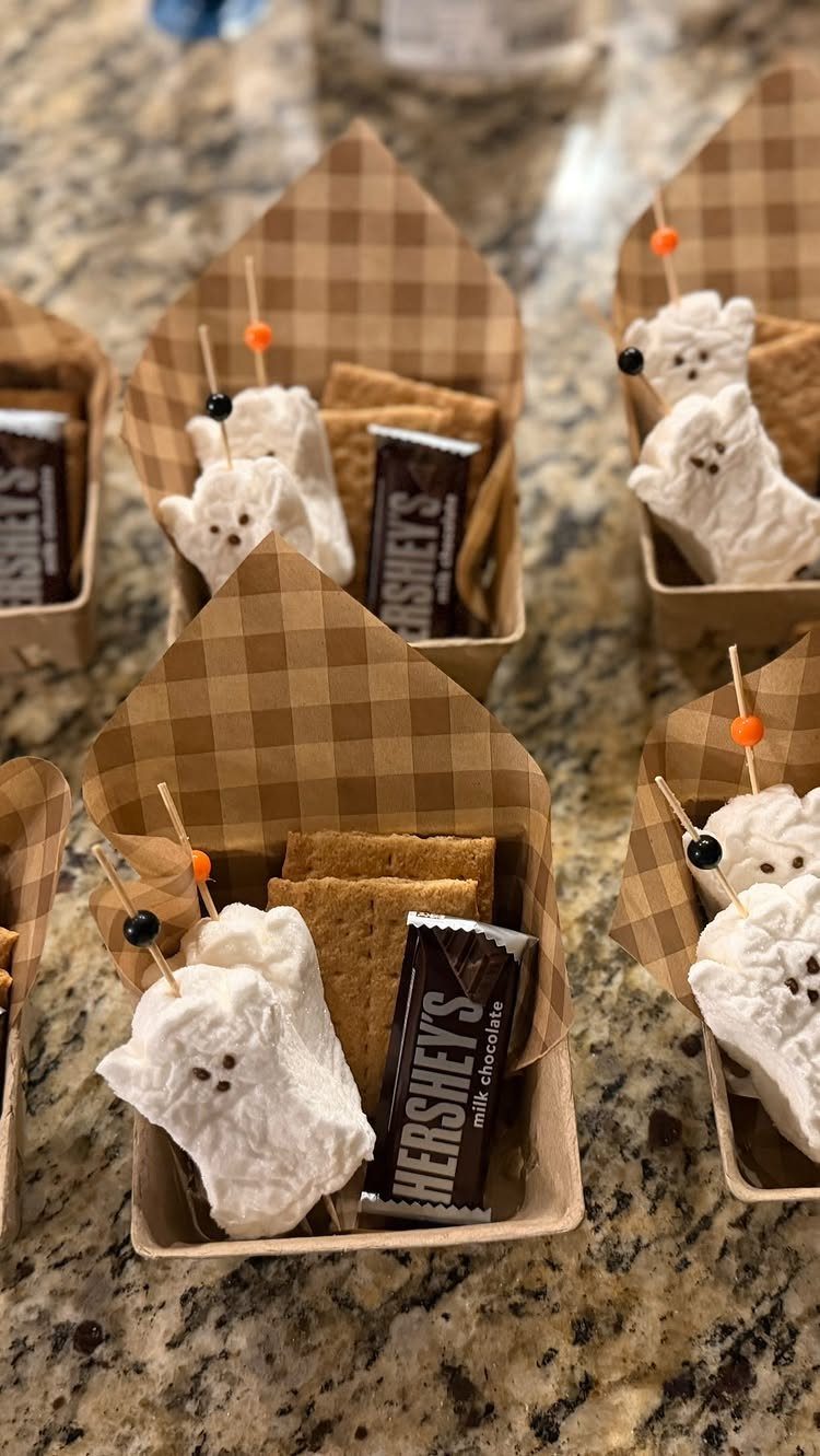 S'mores kits in cardboard boxes with ghost-shaped marshmallows, chocolate, and graham crackers.