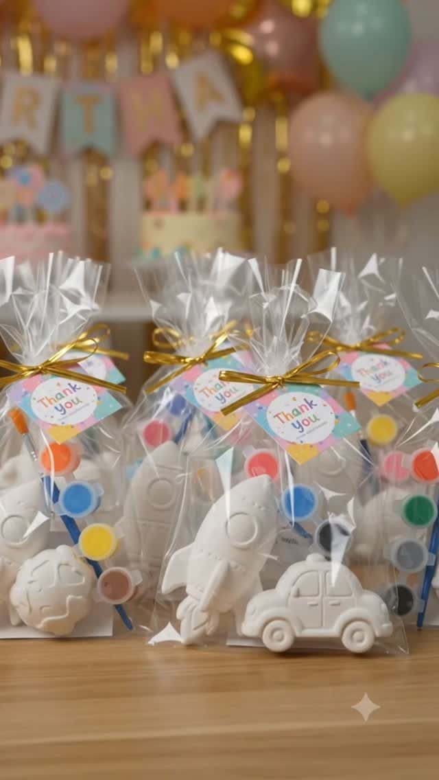 Clear plastic gift bags containing white plaster figures and paint sets for kids.