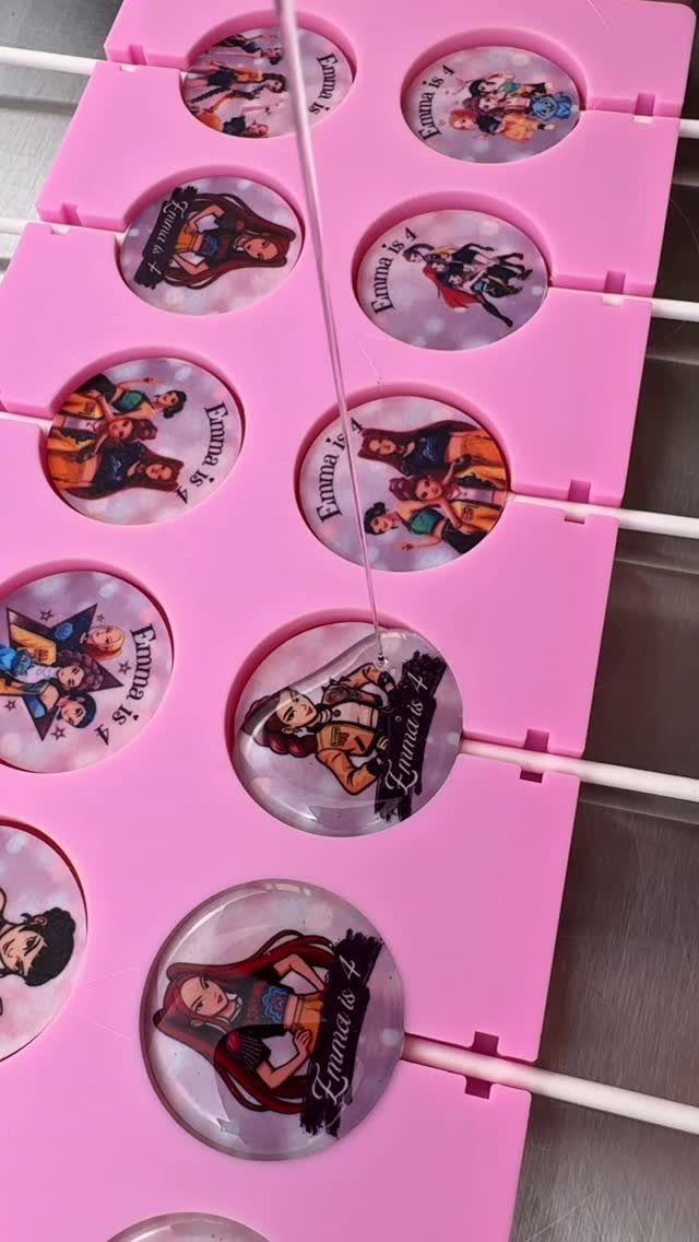 Custom lollipops with character images and birthday text in a pink holder