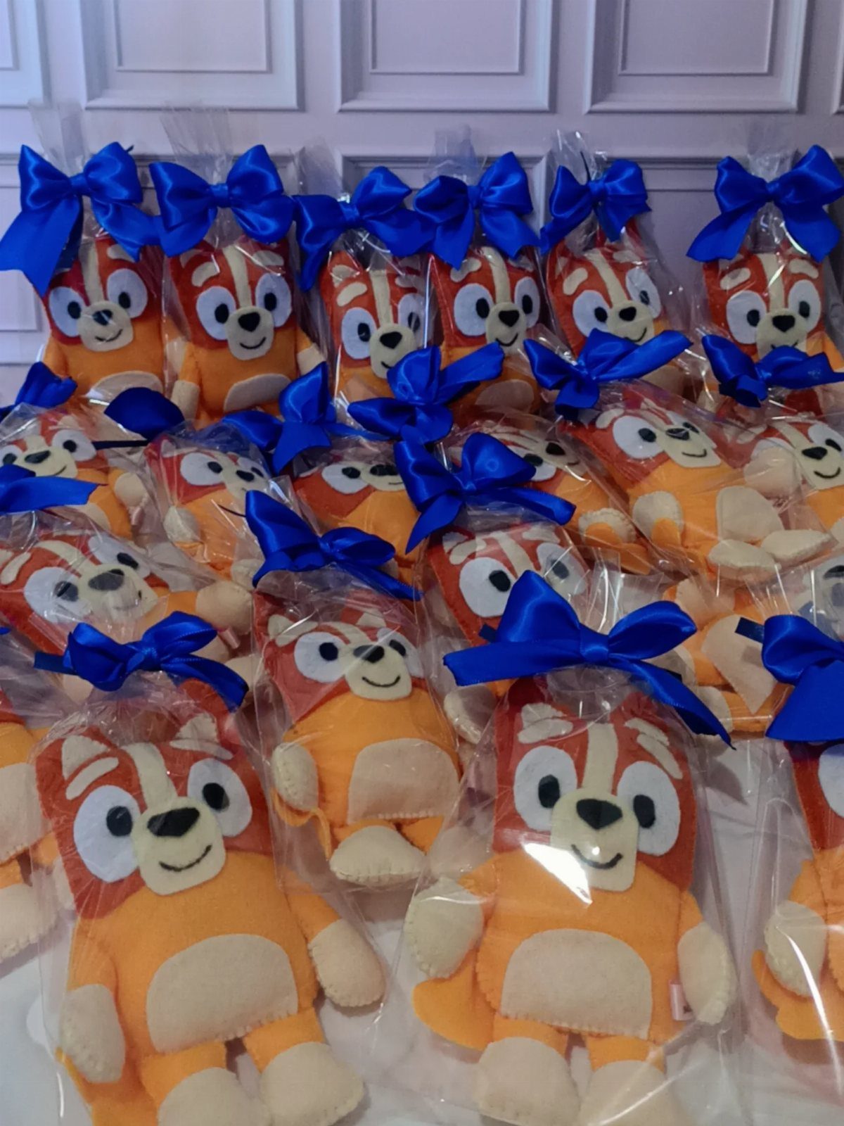 Small orange fox plush toys in clear bags tied with blue ribbons.