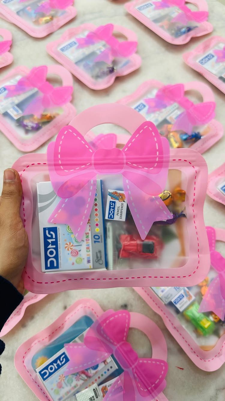 Pink clear plastic gift bags filled with small toys and stationery for parties.