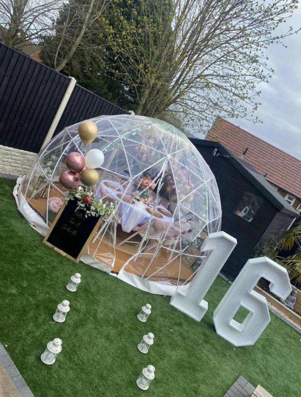 Clear geodesic dome party room with balloons and large number 16 on grass