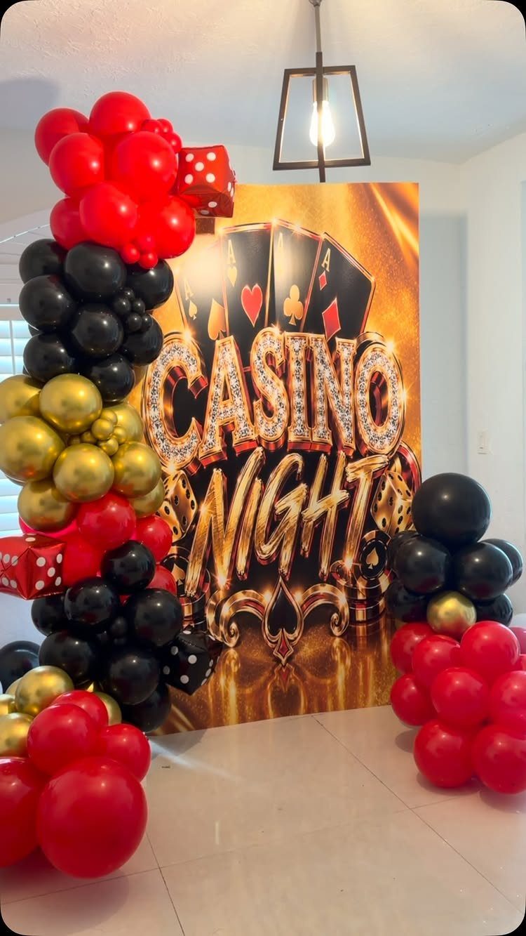 Casino Night backdrop with red, black, and gold balloon arches and dice accents.