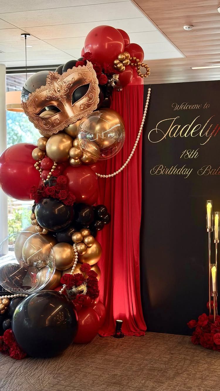 Gold masquerade mask and red, black, and gold balloons for an 18th birthday ball.