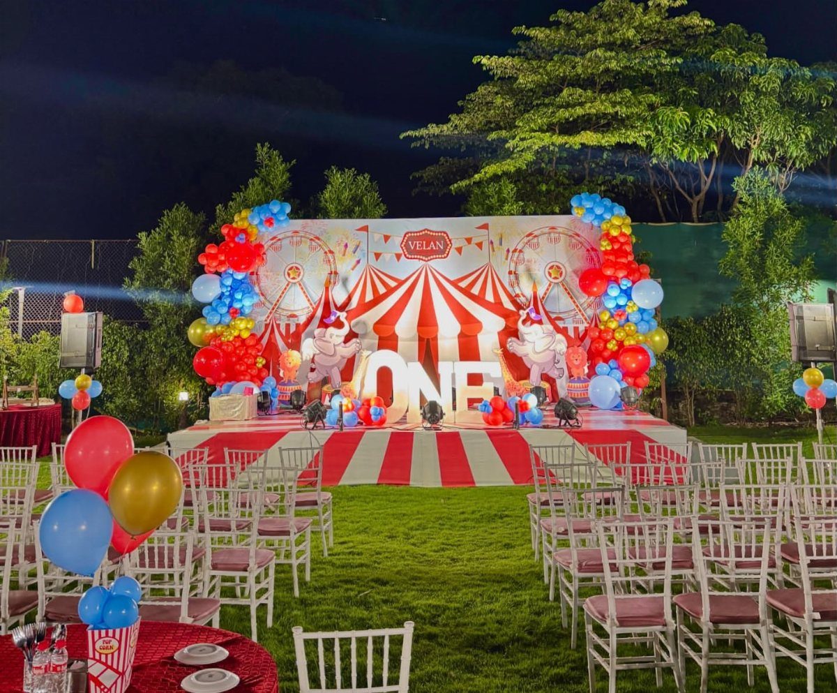 Carnival themed first birthday party setup with red and white striped tent backdrop.
