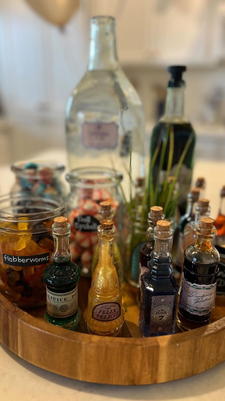 Wooden tray with potion bottles and candy jars for a magical party theme.