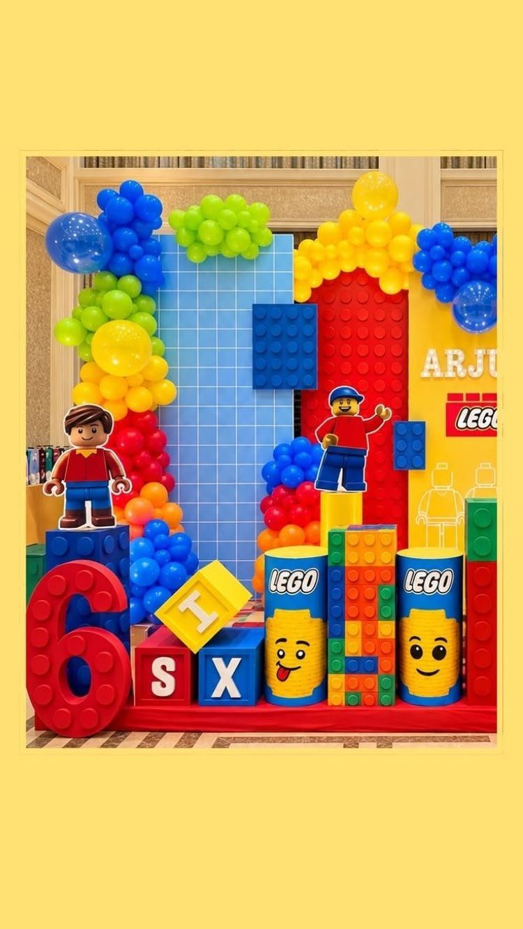 Lego themed birthday party setup with colorful blocks, balloons, and minifigure cutouts.