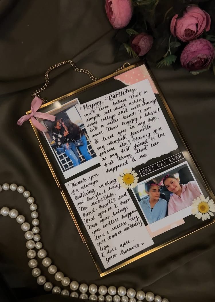 Gold glass frame with photos and handwritten birthday notes on dark fabric.