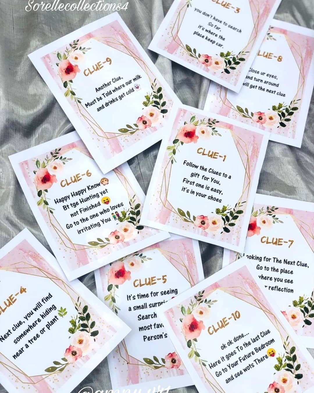 Floral clue cards for a treasure hunt scattered on a grey fabric background.