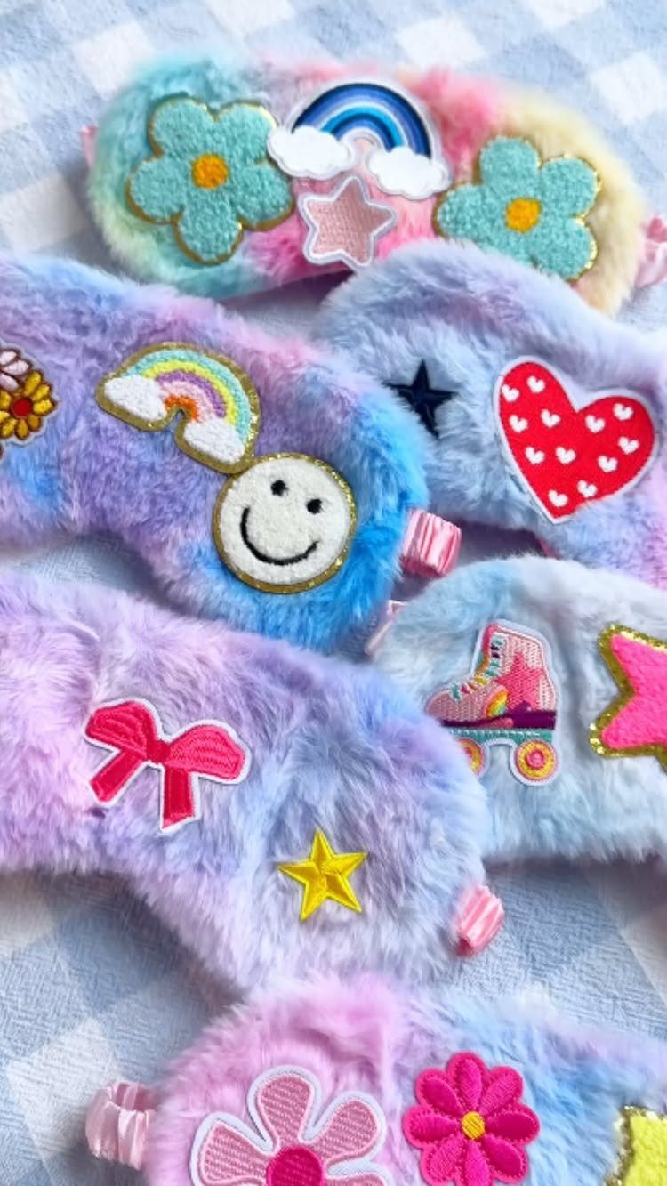 Pastel fluffy sleep masks with colorful patches on a checkered blue background