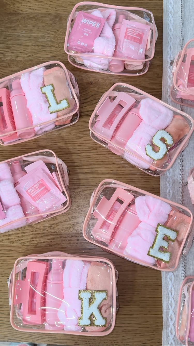 Pink spa-themed goody bags in clear pouches with glittery gold initials.