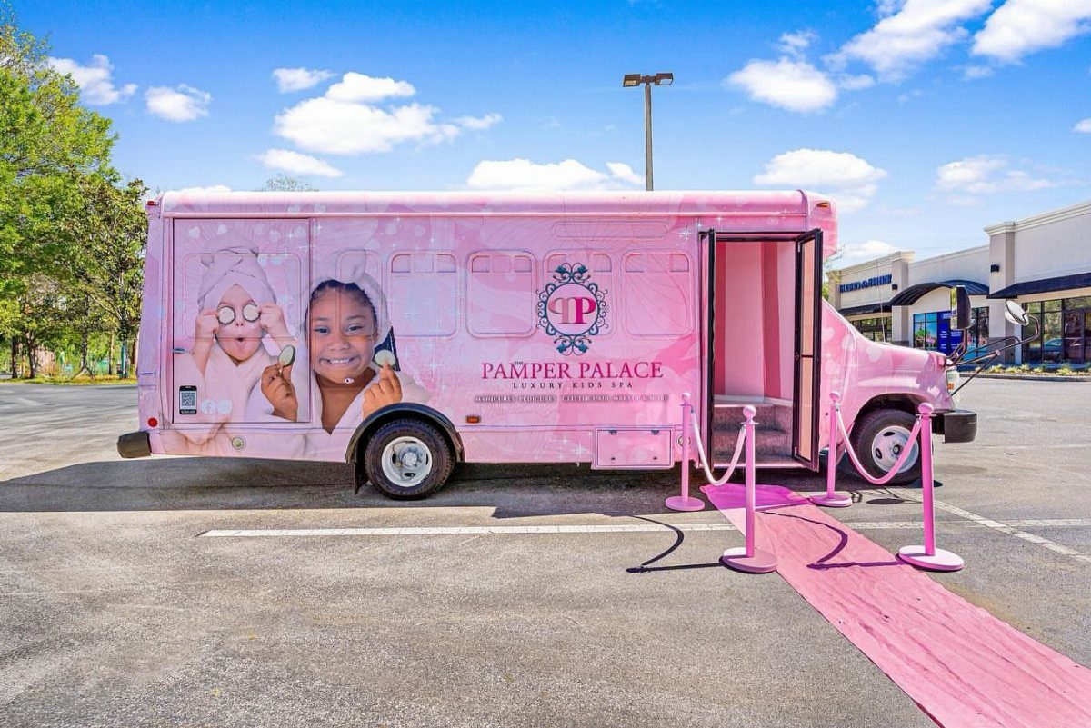 Pink mobile spa van with a pink carpet entrance in a parking lot
