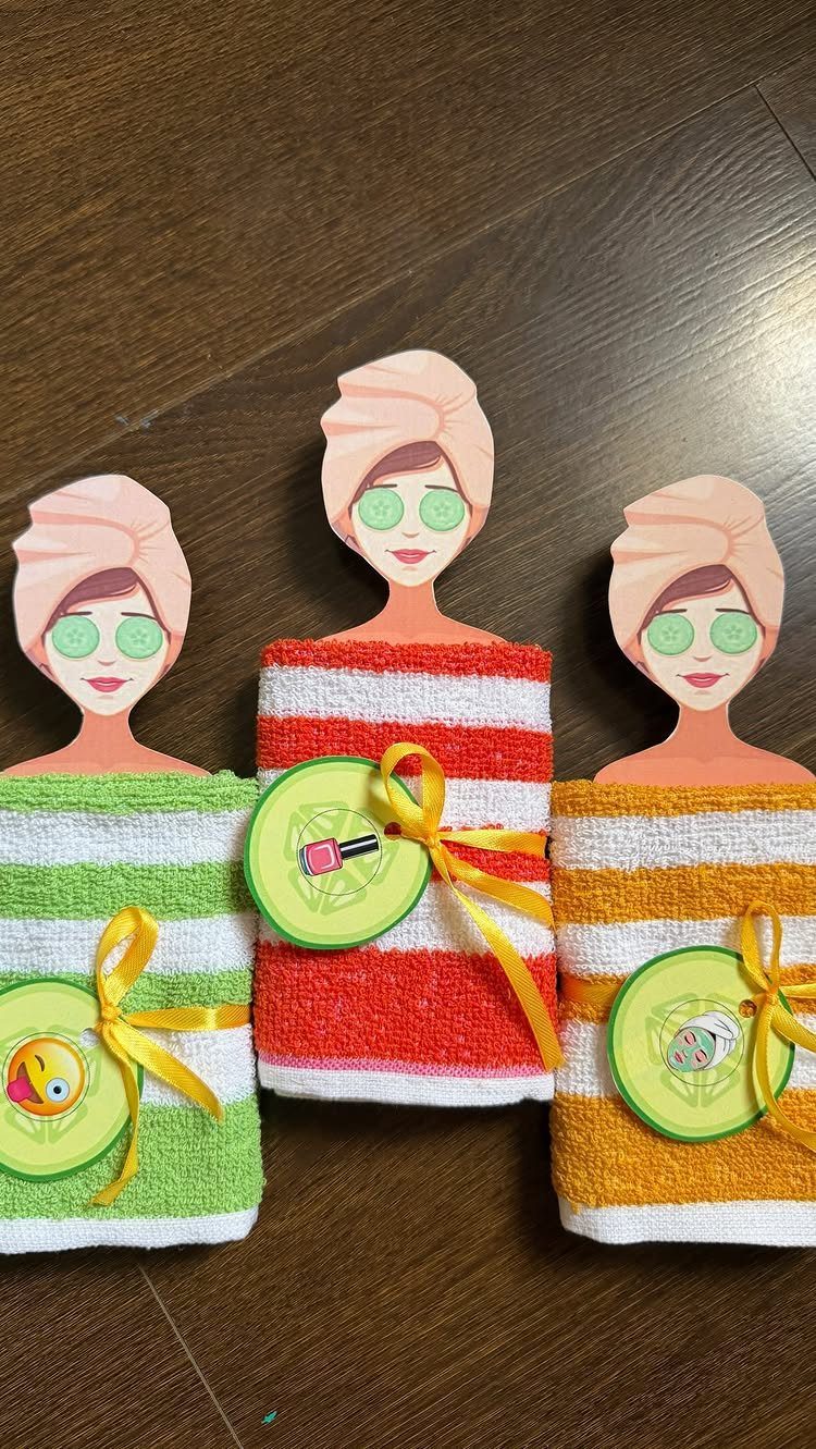 Rolled striped towels decorated as spa figures with cardboard faces and cucumber slices.