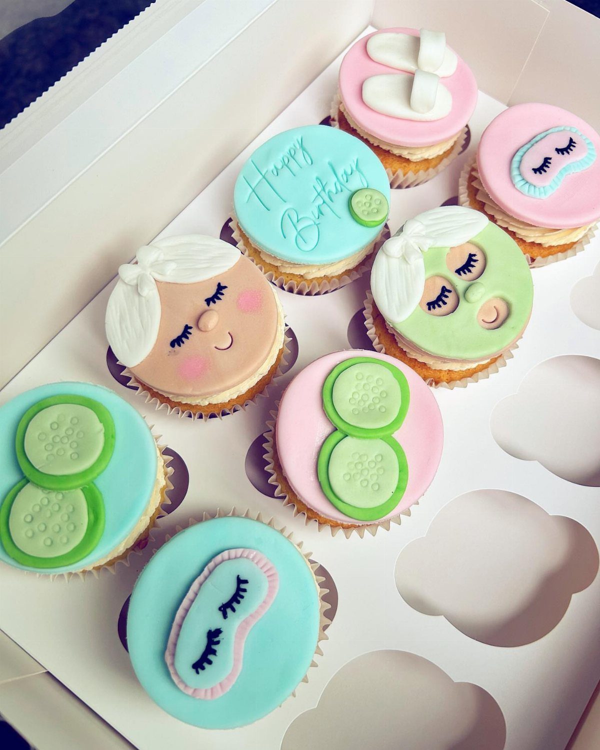 Spa themed birthday cupcakes with fondant cucumber slices, sleep masks, and slippers.