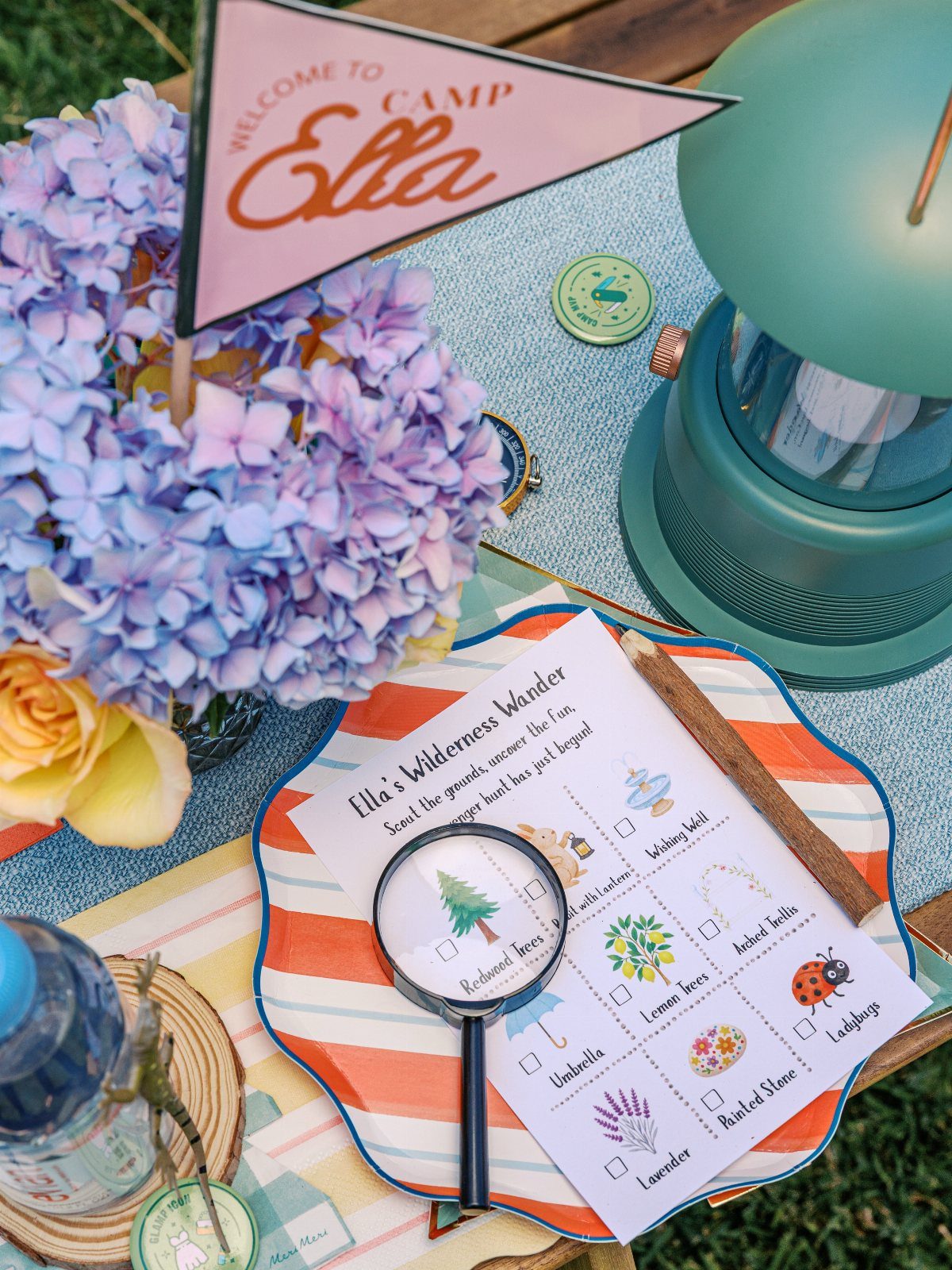 Scavenger hunt list with a magnifying glass, lantern, and flowers on a table.