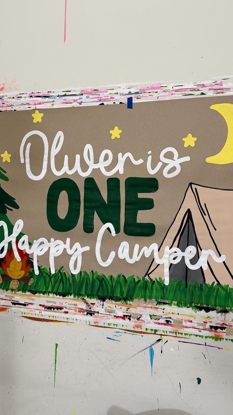 Painted camping banner with a tent and campfire reading Oliver is ONE Happy Camper