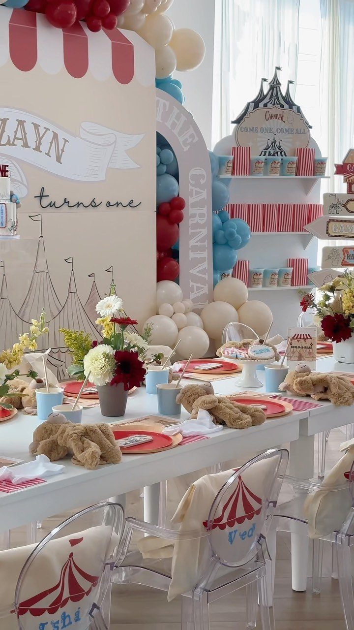 Carnival themed first birthday party table setting with red and white circus decorations.