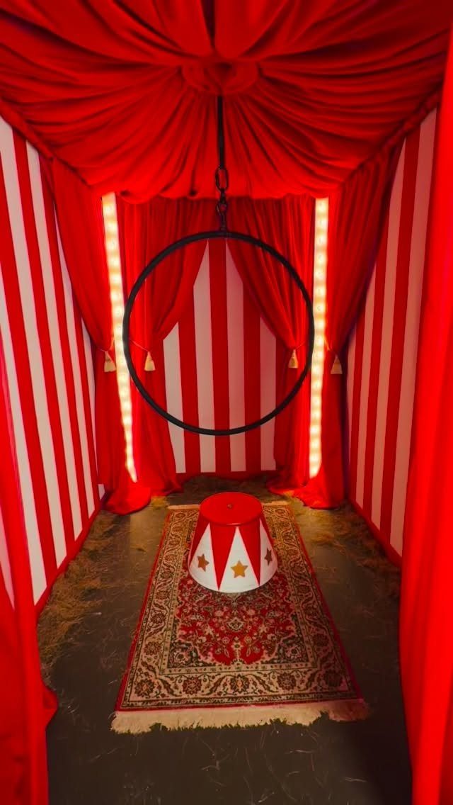 Circus themed room with red and white stripes, aerial hoop, and star pedestal.