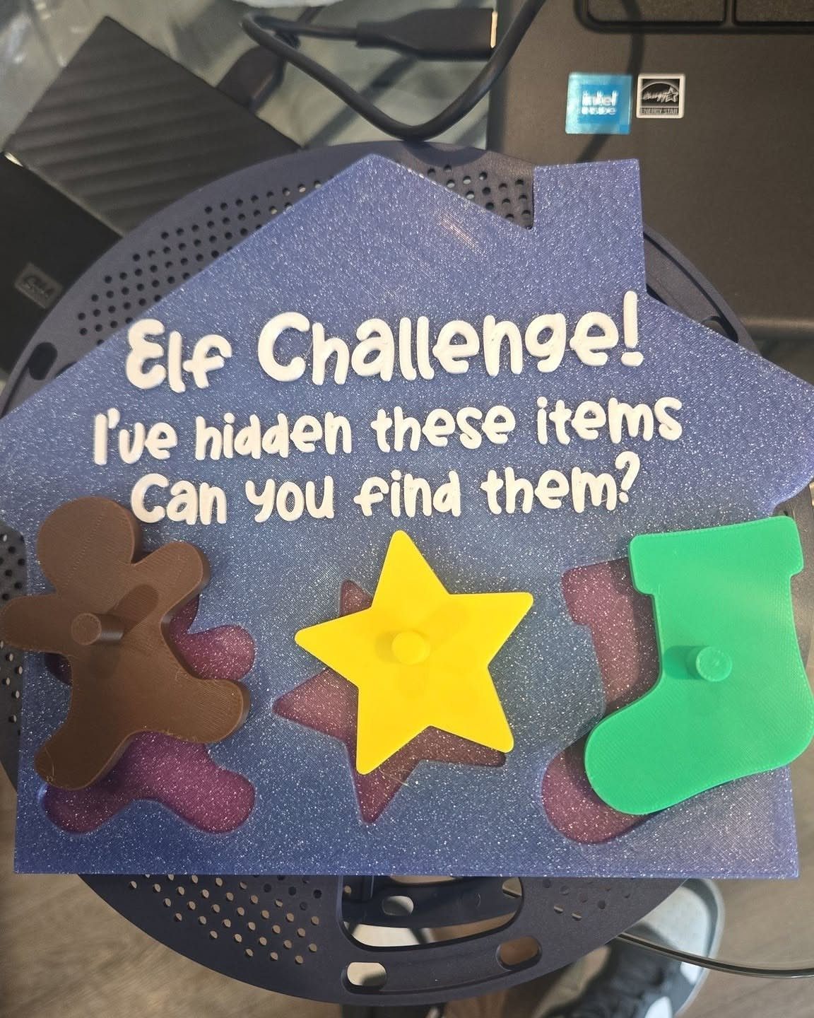 Purple glittery house board for a Christmas scavenger hunt with plastic holiday shapes.