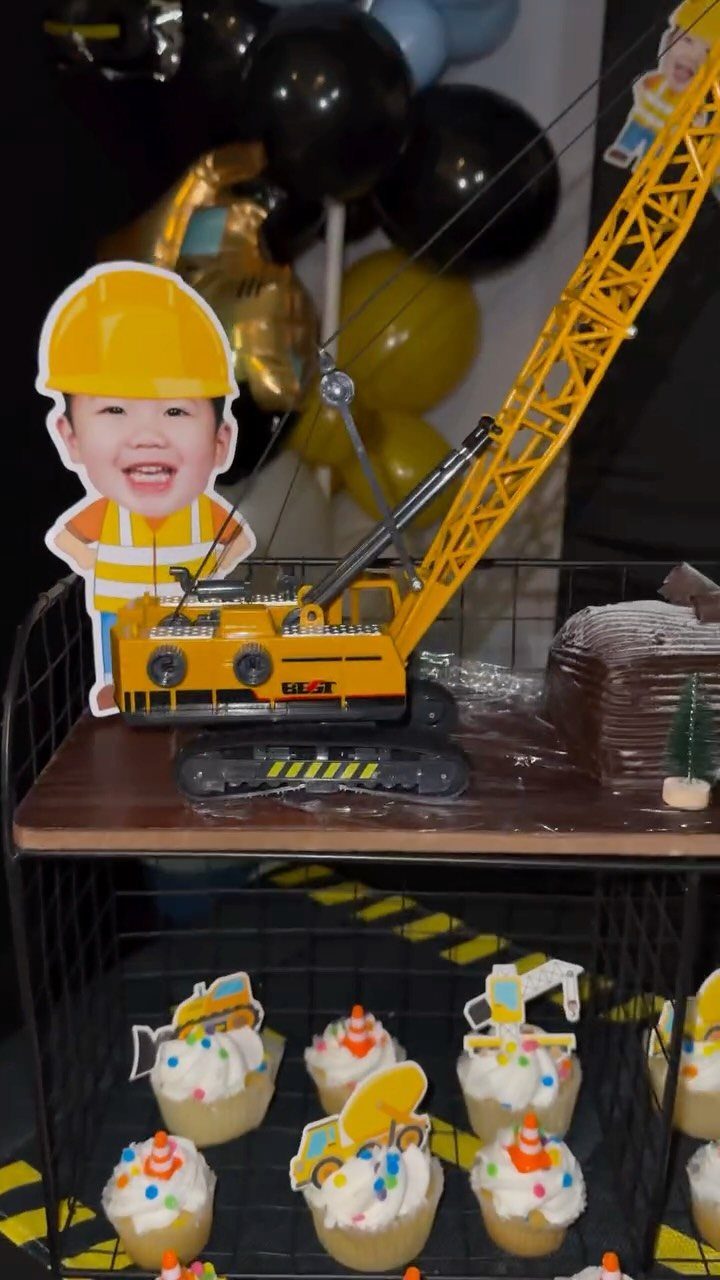 Toy yellow crane and construction cupcakes on a themed party dessert table.