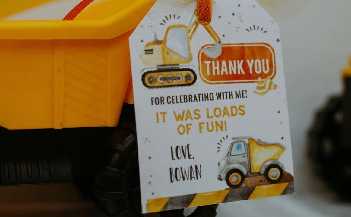 Yellow toy dump truck with a construction-themed thank you gift tag attached.