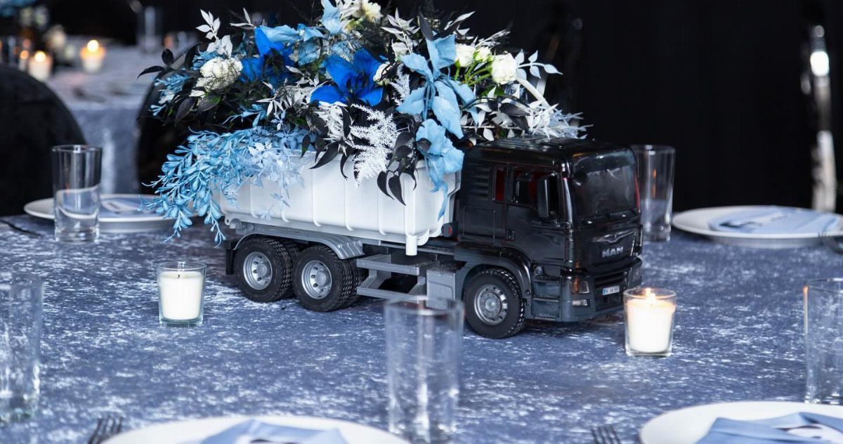 Black toy dump truck filled with blue and white flowers as a table centerpiece